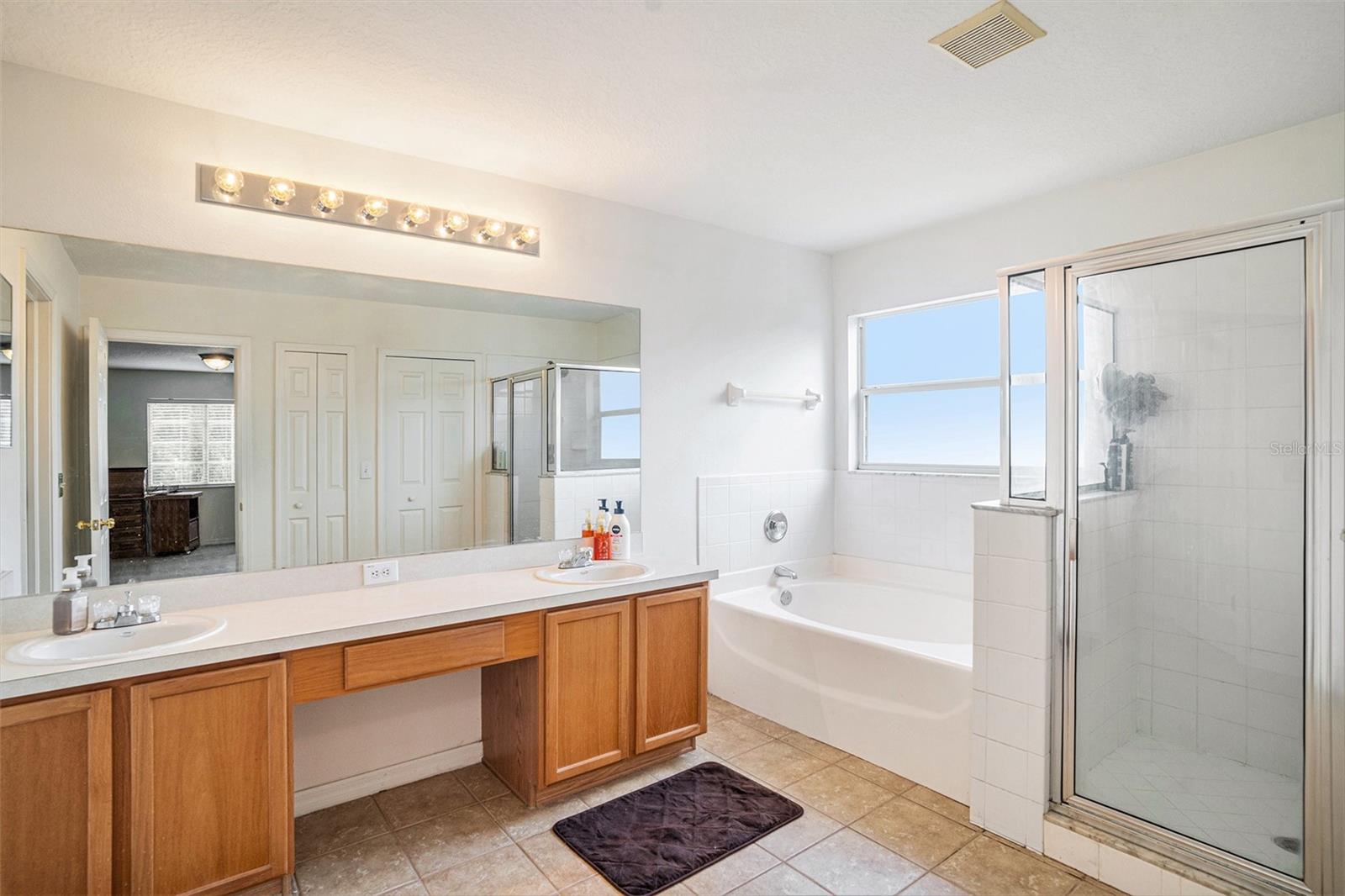 Primary En suite featuring a double vanity, separate tub & shower, private toilet, and multiple closets!