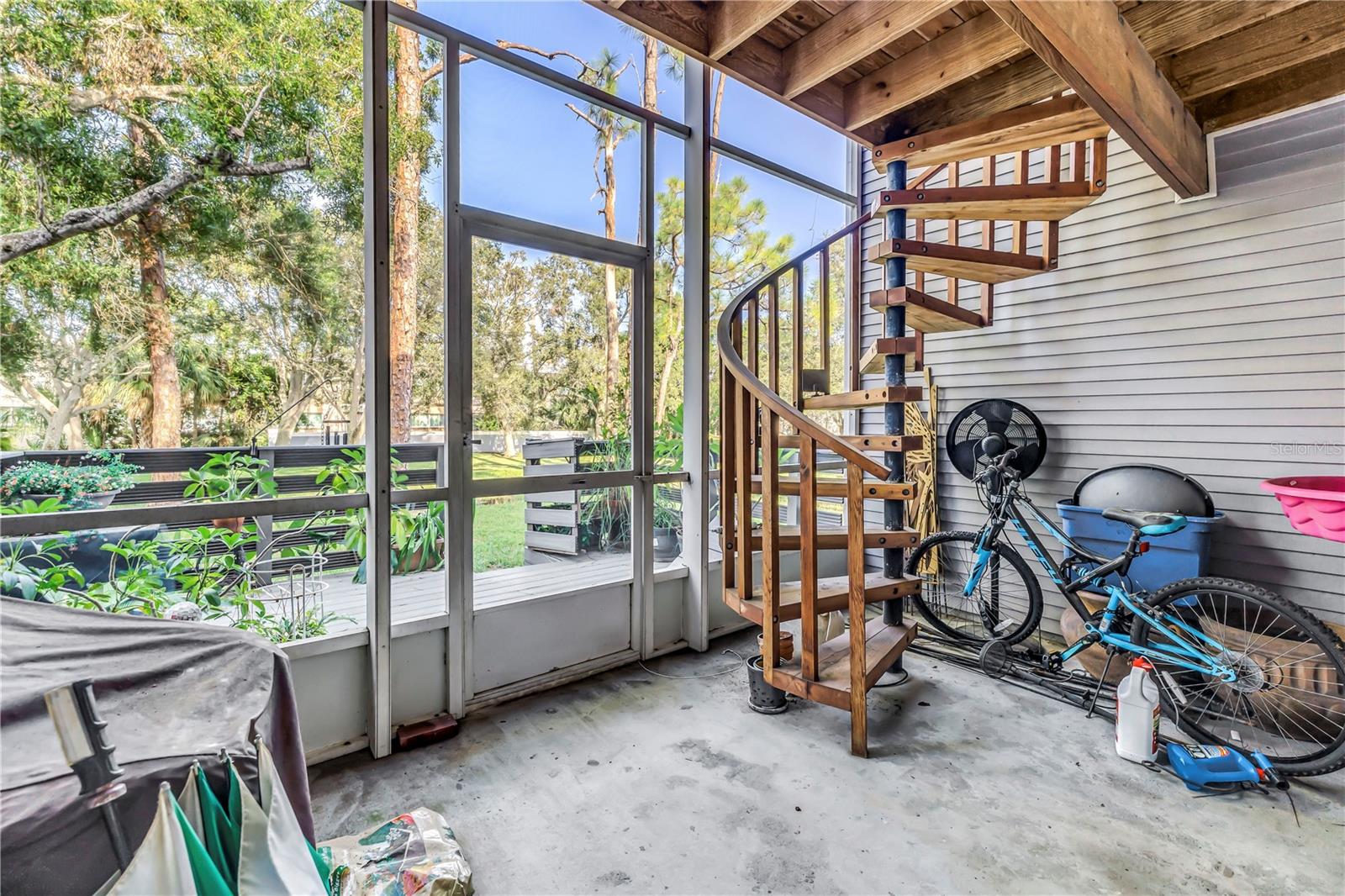 Screened patio outside flex space with spiral staircase to 2nd floor and access to exterior patio