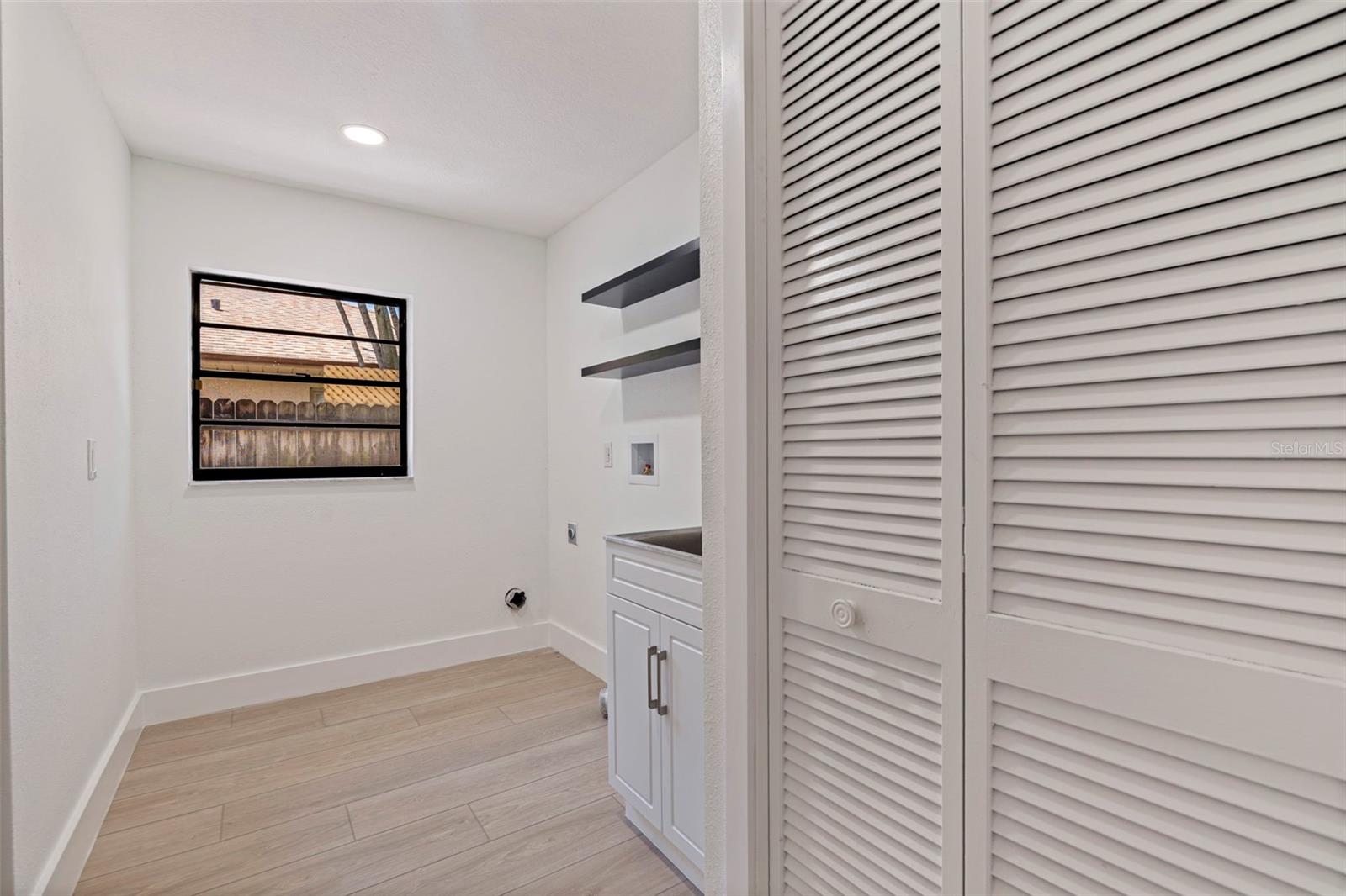 Laundry room and storage closet with sink