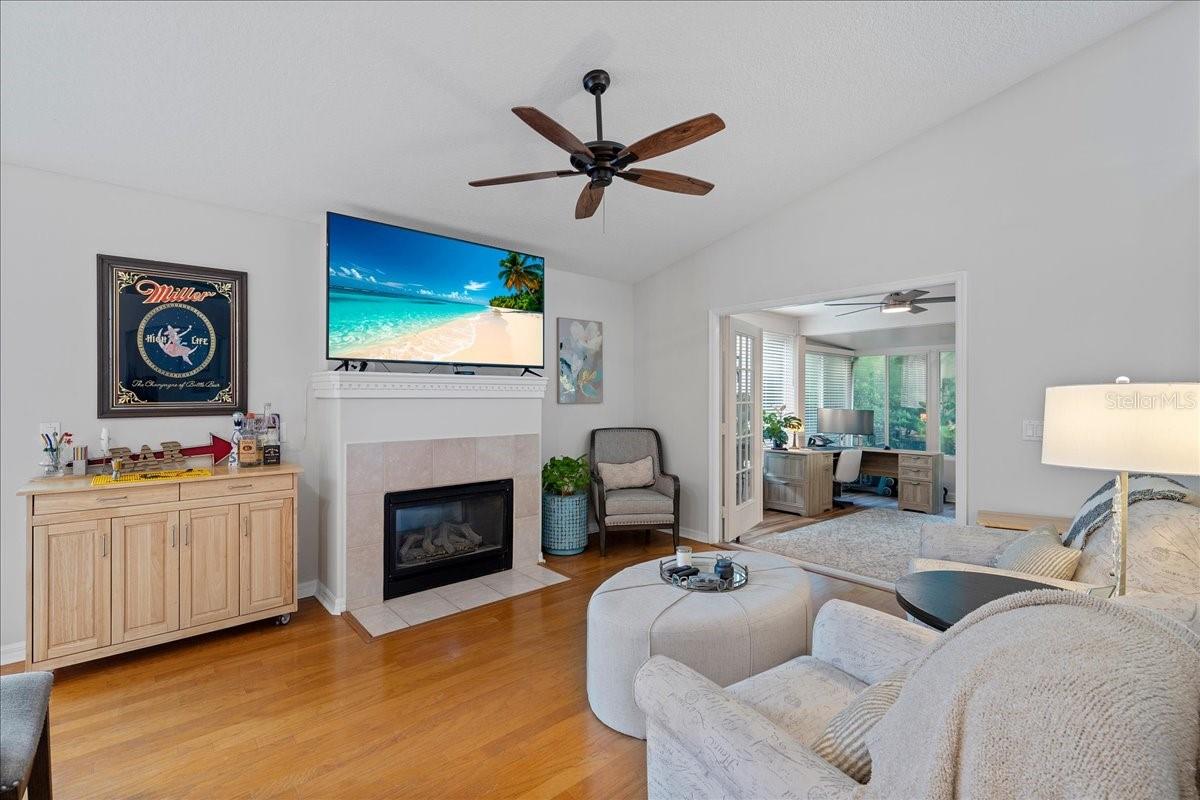 Family room with cozy fireplace and French doors to the Florida room/ sunroom.
