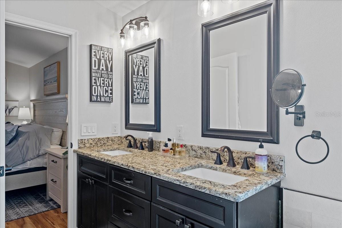 Primary ensuite bathroom with dual sink vanity, modern fixtures, soaking tub and large stand-up shower