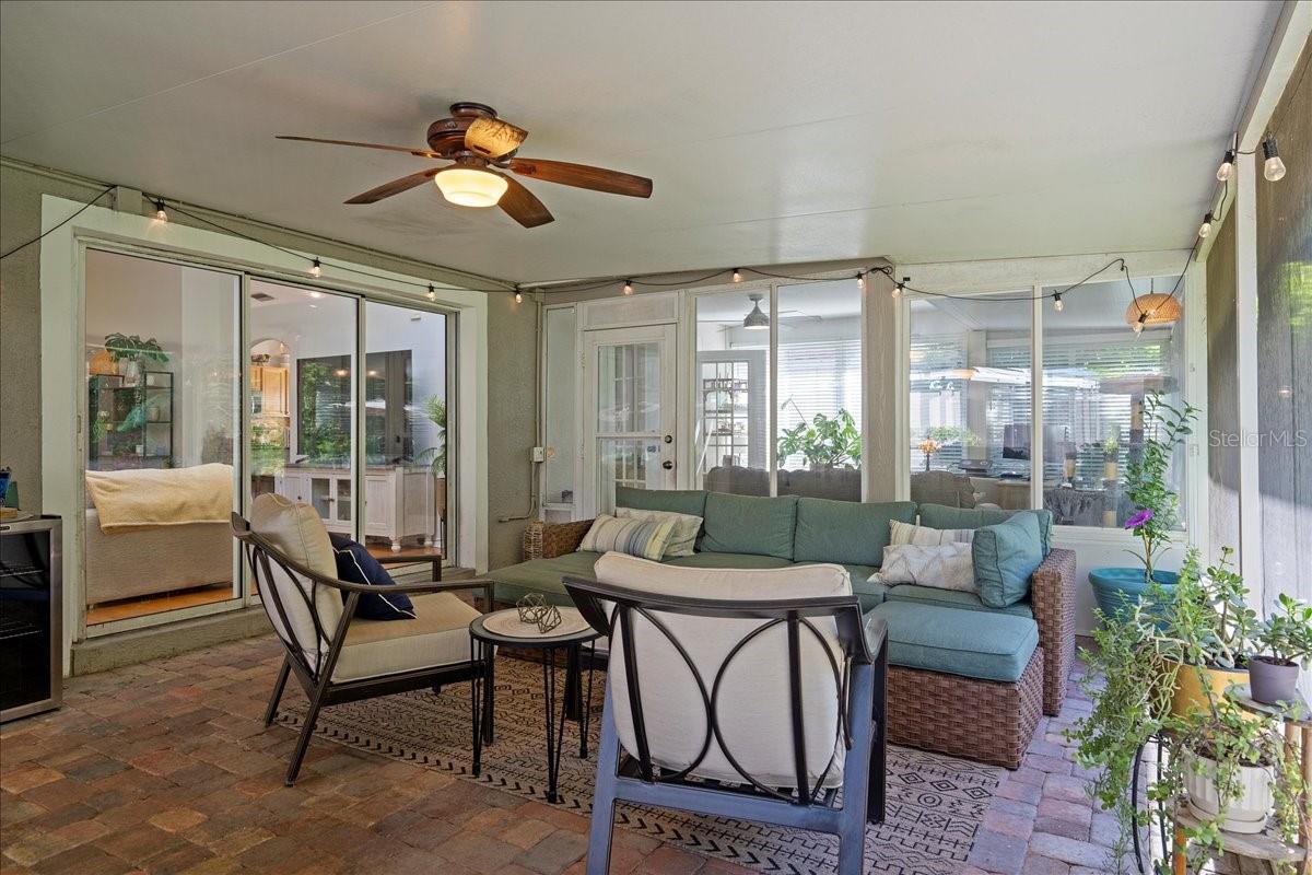 Spacious screened-in patio with paver tile flooring, two ceiling fans and glass sliders from the living room and door to the Florida room/sunroom offers a protected outdoor setting ideal for year-round enjoyment.
