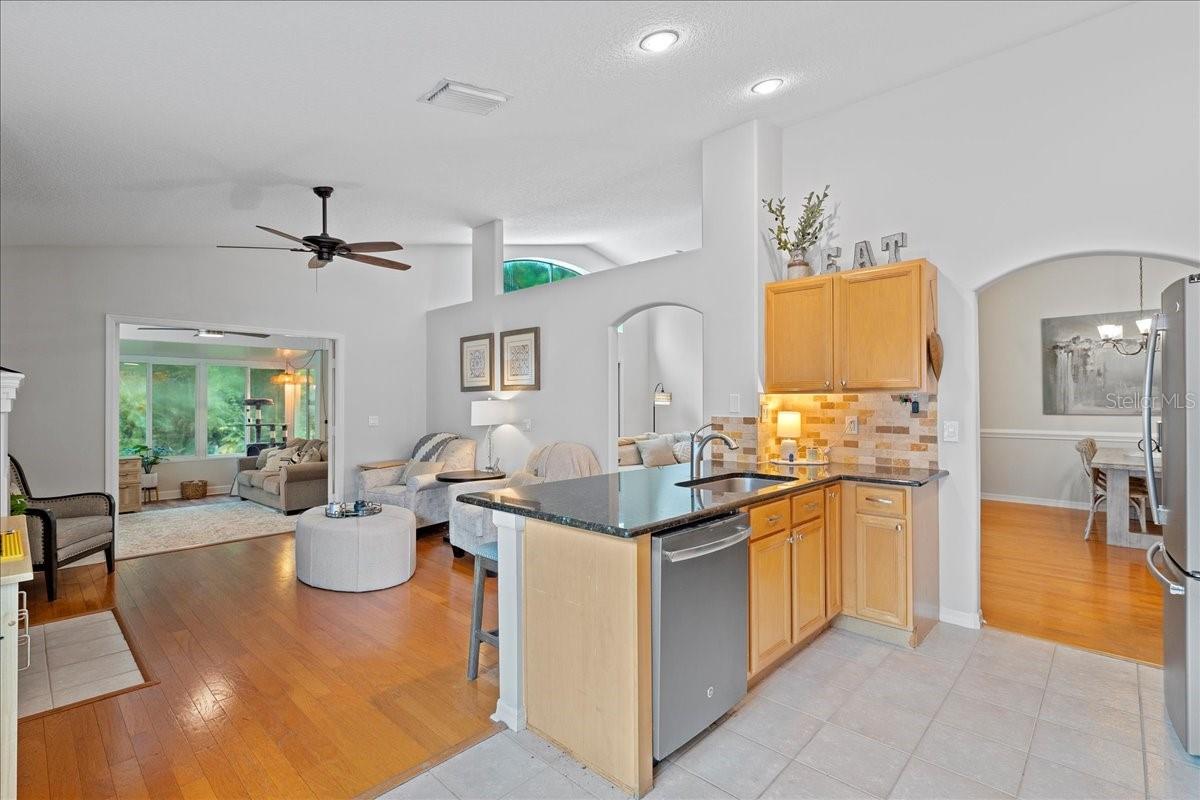 Open concept kitchen is well -equipped with stainless steel appliances, ceramic tile floors, and breakfast bar