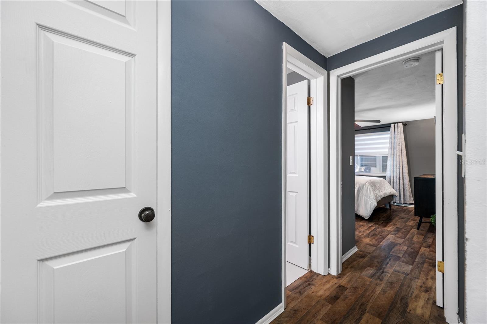 Split plan features storage closet, primary bedroom on the right, bathroom in center and second bedroom to the left.