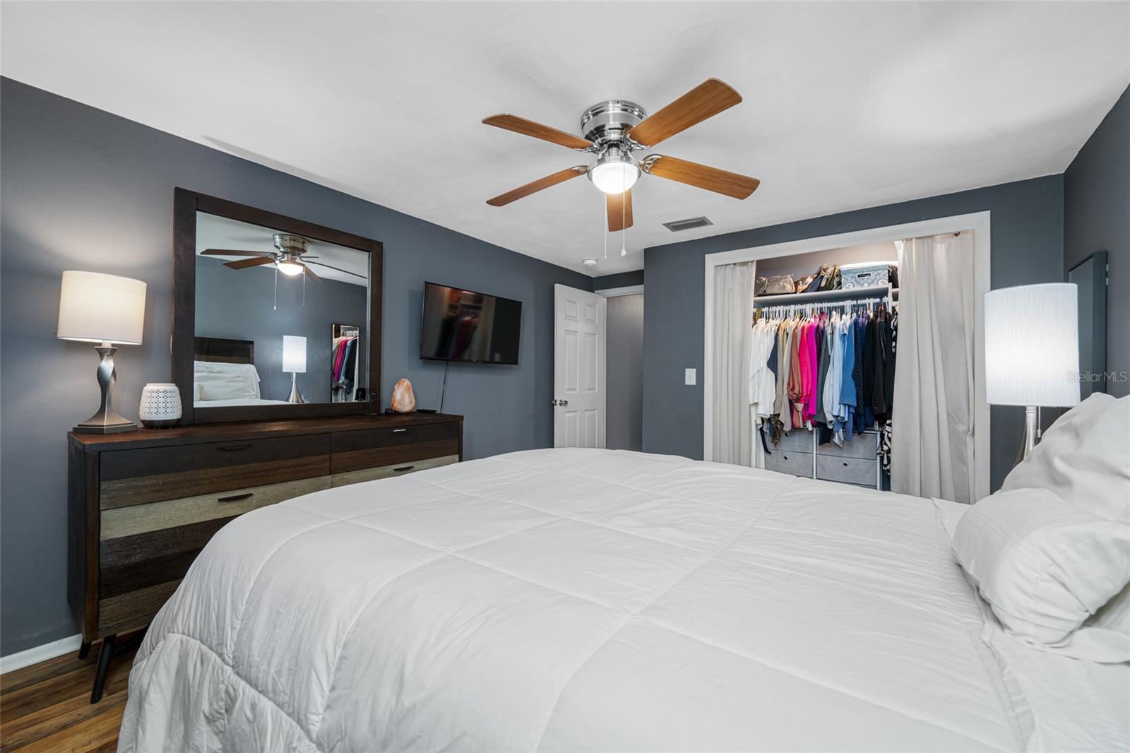 Primary bedroom has lighted fan, LVP flooring, updated window and updated built in closet