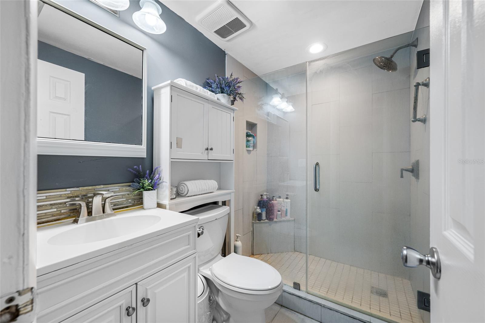 Updated bathroom has exhaust fan, stand up shower and tile flooring