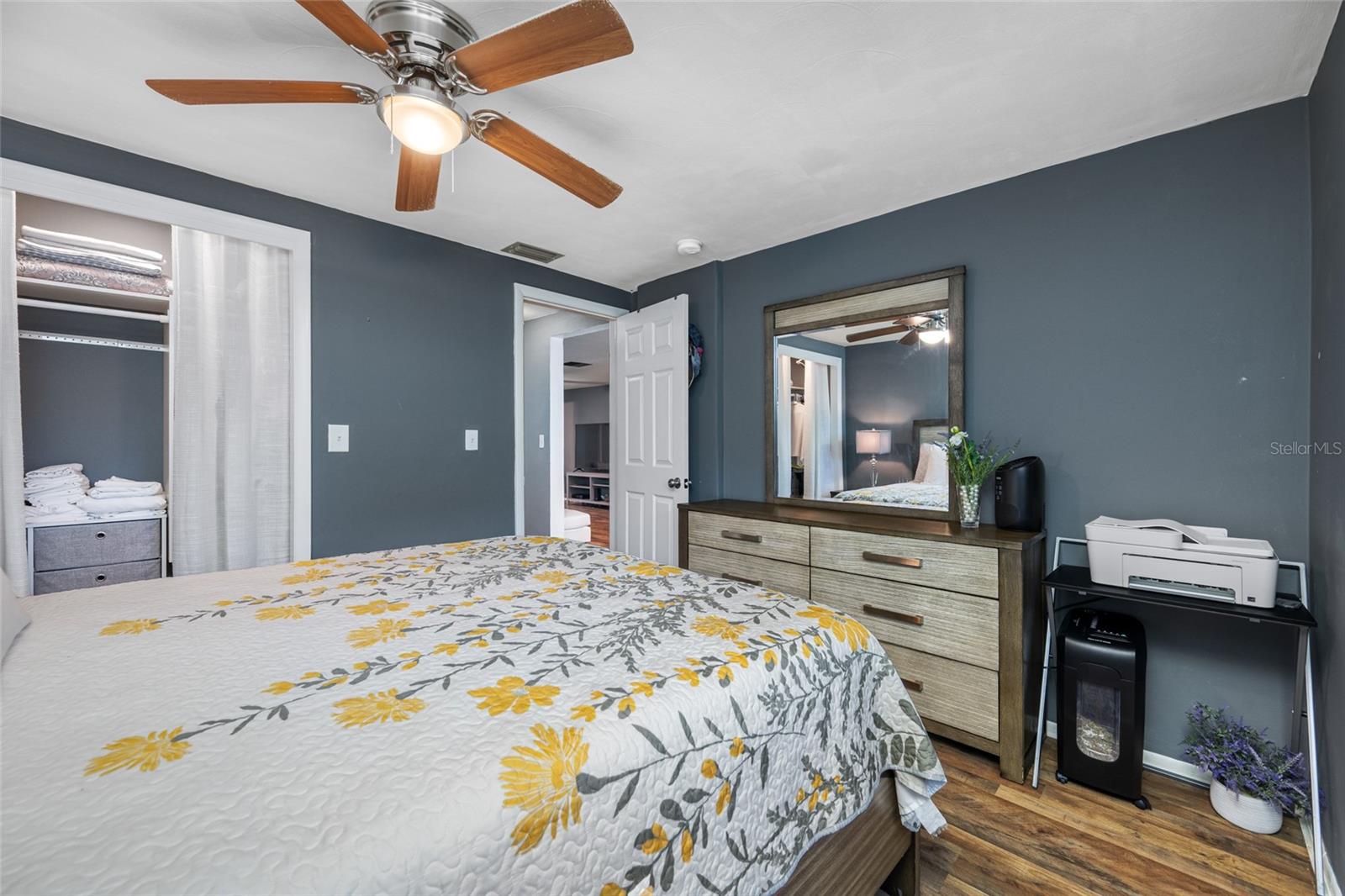 Second bedroom has updated lighted fan, built in closet, LVP flooring and custom shade.