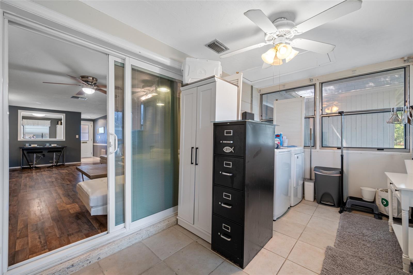 Flex space leading to back yard doubles as private inside laundry with large wash sink and storage closet.