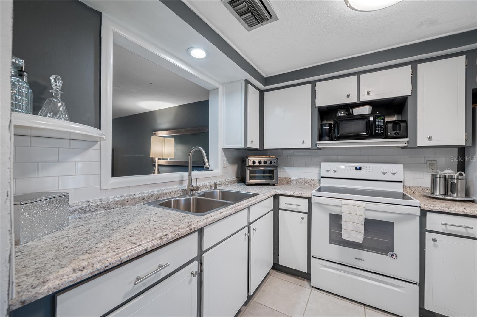 Updated kitchen features large Kohler sink, luxury faucet, garbage disposal, neutral countertops and newer appliances.