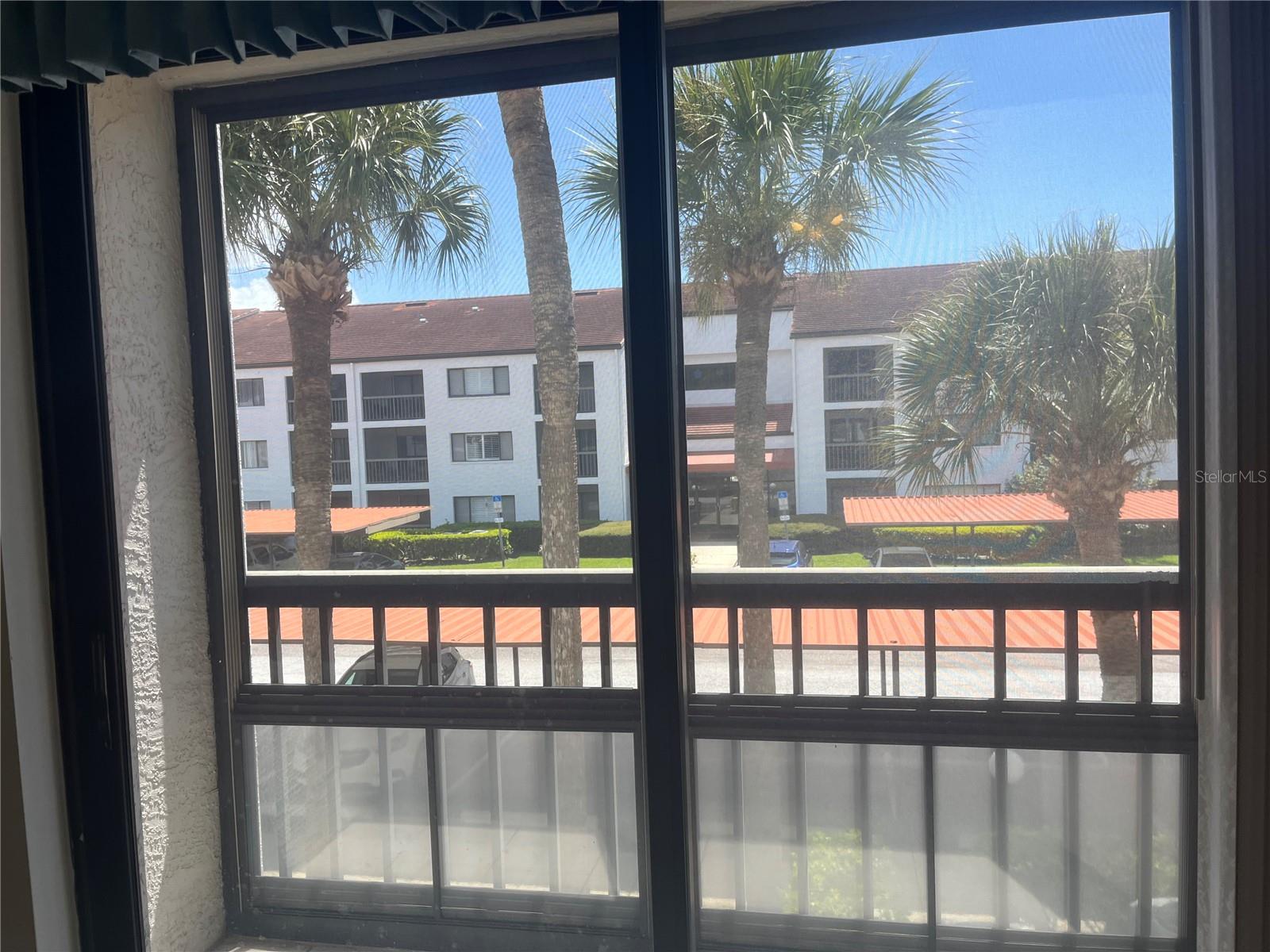 Primary bedroom view to screened balcony that also has vinyl windows that pull up to the ceiling