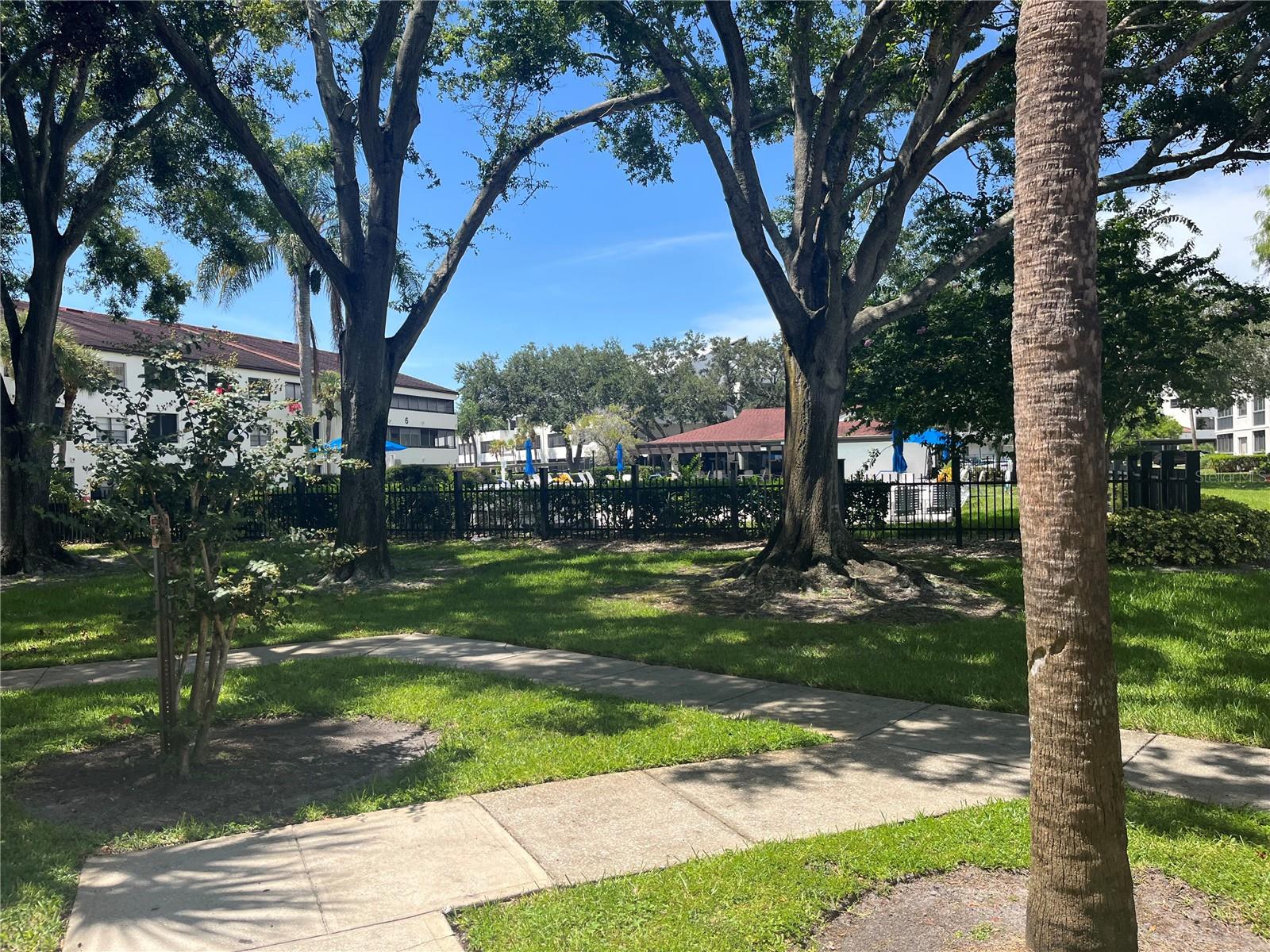 Short sidewalk walk to mature landscaping , large pool and clubhouse