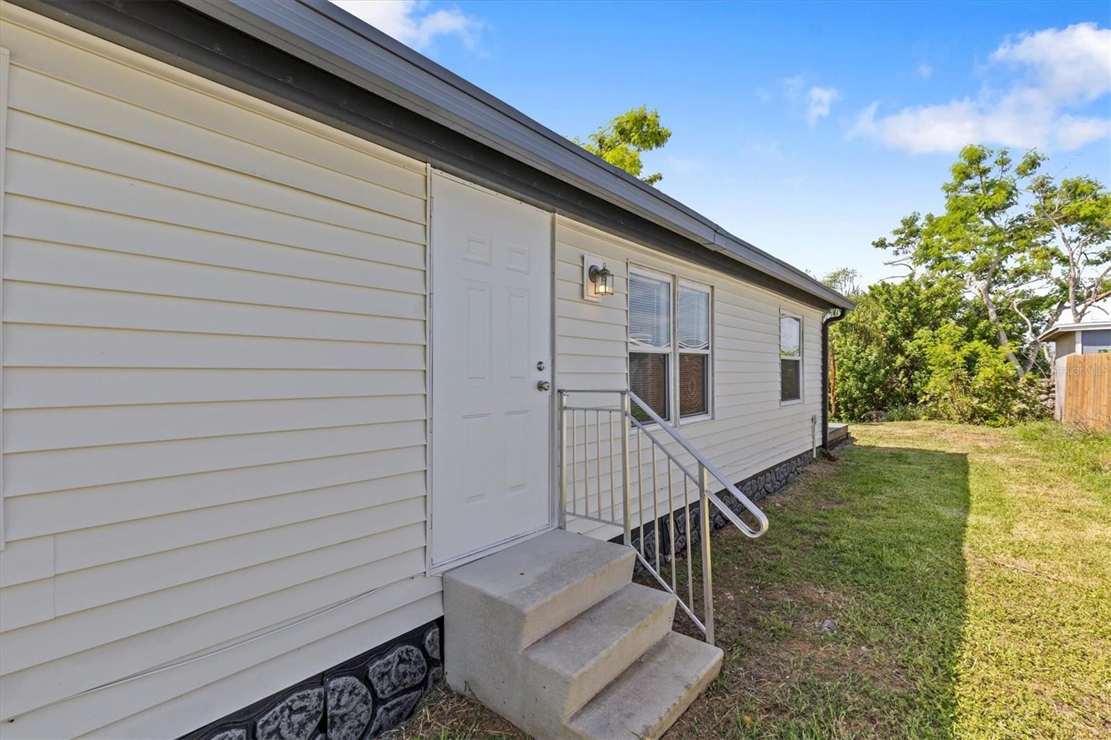 Back of the home with a additional exit door from the living room