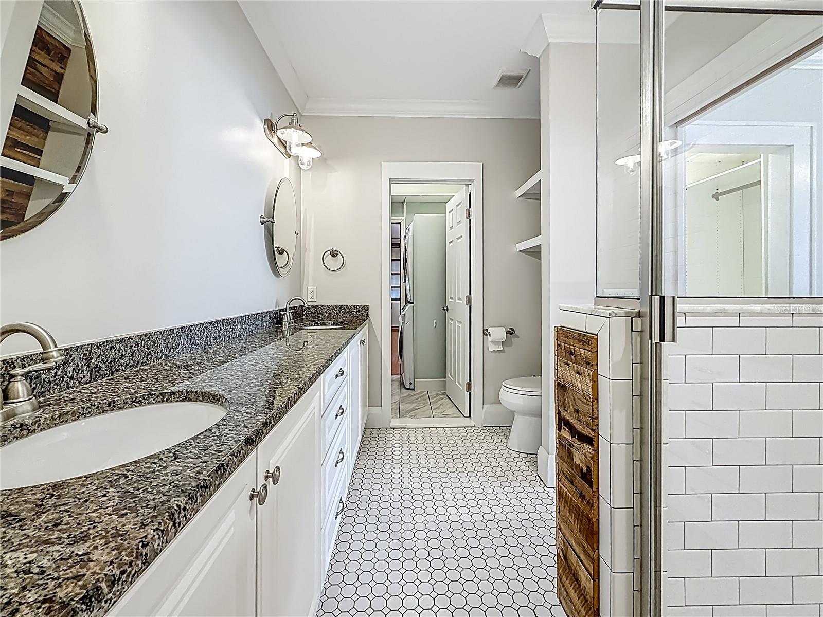MBR Bathroom w/ view of Shower to right, Laundry Rm in back