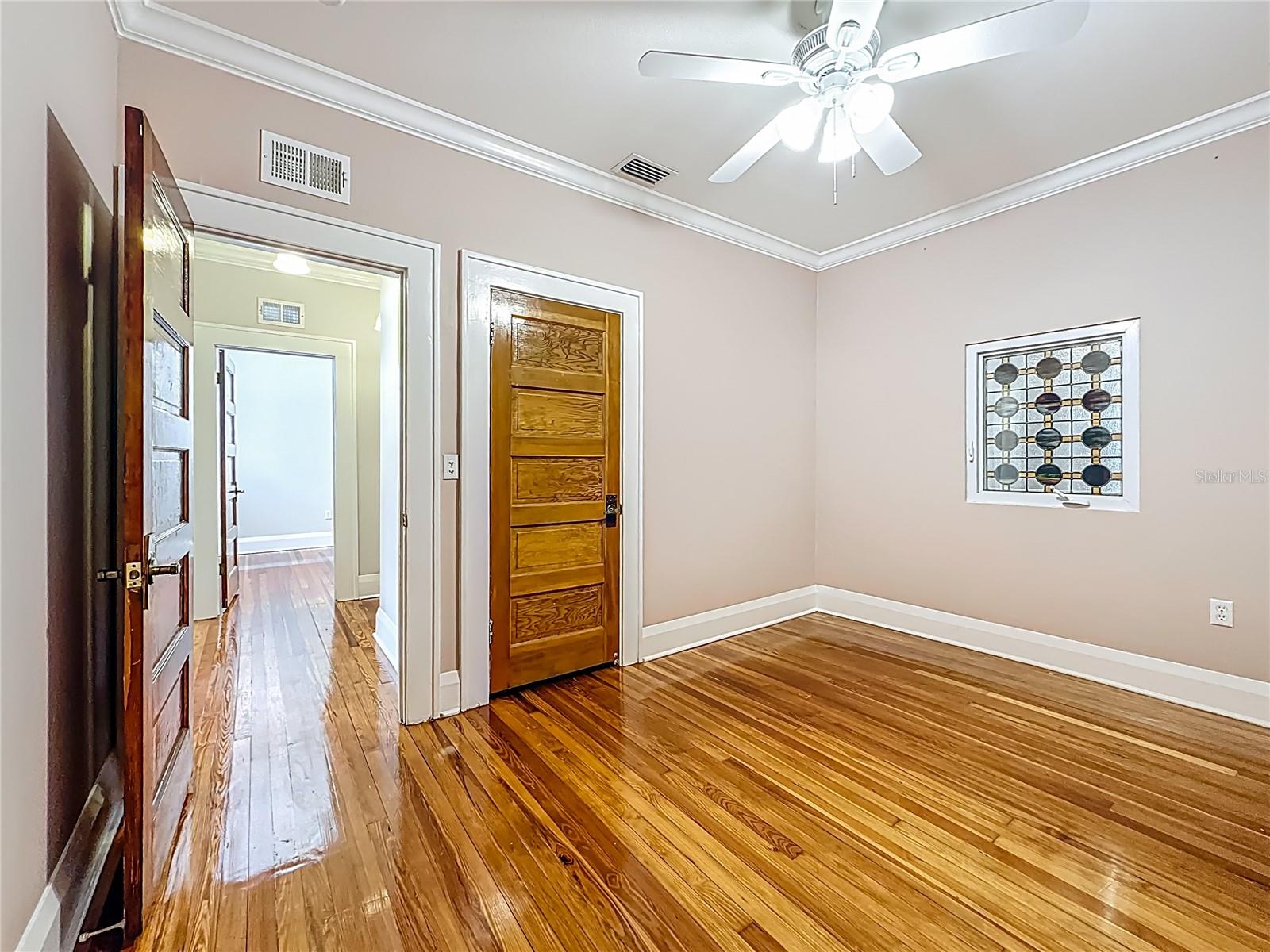 2nd Bedroom with view of Entry Door, Closet, Stained Glass Window