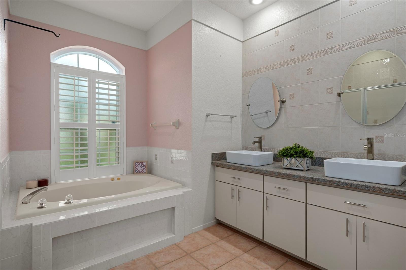 His and her raised porcelain sinks make the primary bathroom more functional.