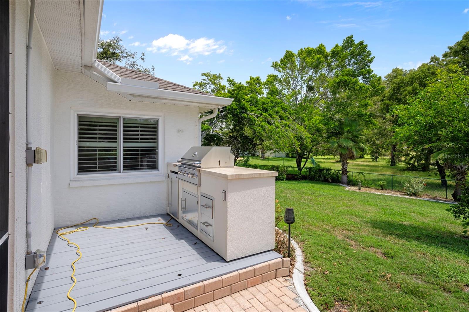 Wonderful wooden deck with Custom built outdoor grill with marble to, storage  and refrigerator