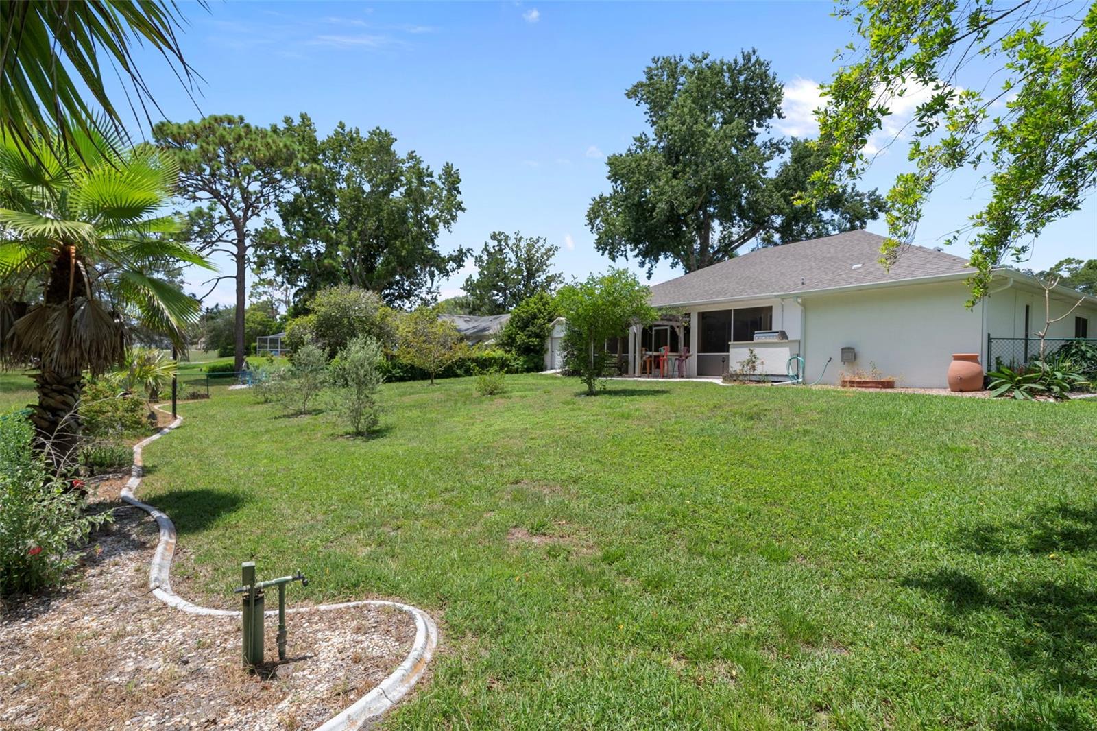 Manicured flower beds with cement landscape borders highlight the fenced in backyard.