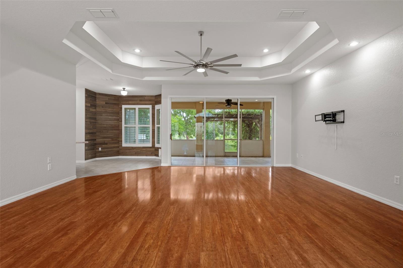Stunning living room with tray ceilings, recessed lights and upgraded beautiful fan/ light and laminate floors.