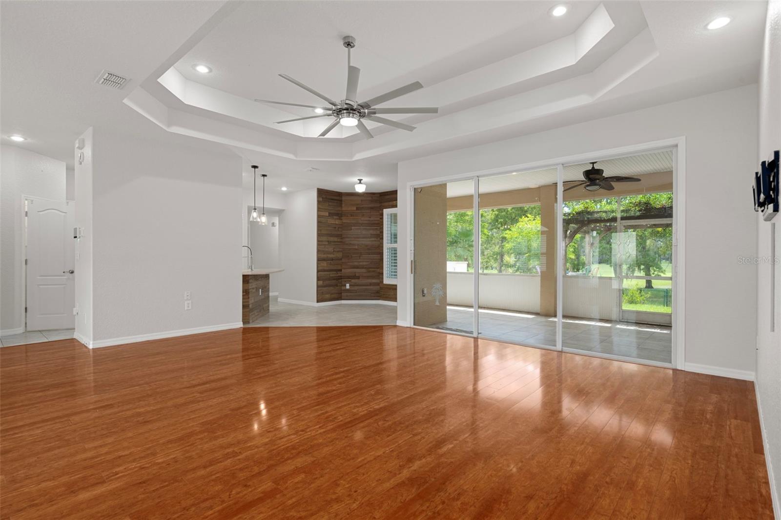 Theres plenty of natural light in the living room thanks to the triple sliding glass doors to the screened in lanai .