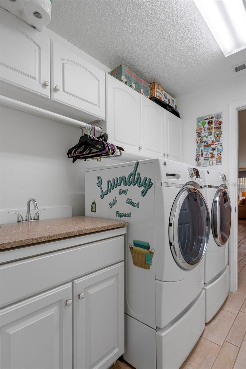 There is a large sink and there is no shortage on cabinet space in this laundry room!