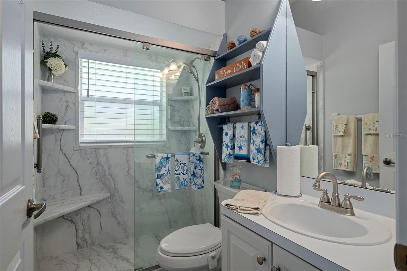 Guest bathroom with marble style custom tiled walk in shower.