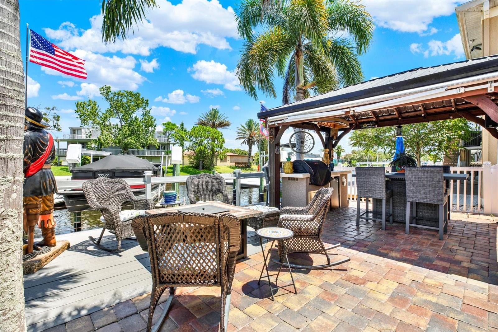 Entertaining made easy with your own outdoor covered  kitchen equipped with BULL gas grill & table / chair seating.    Evening lights made for an amazing ambiance!  FIRE PIT & chairs convey !