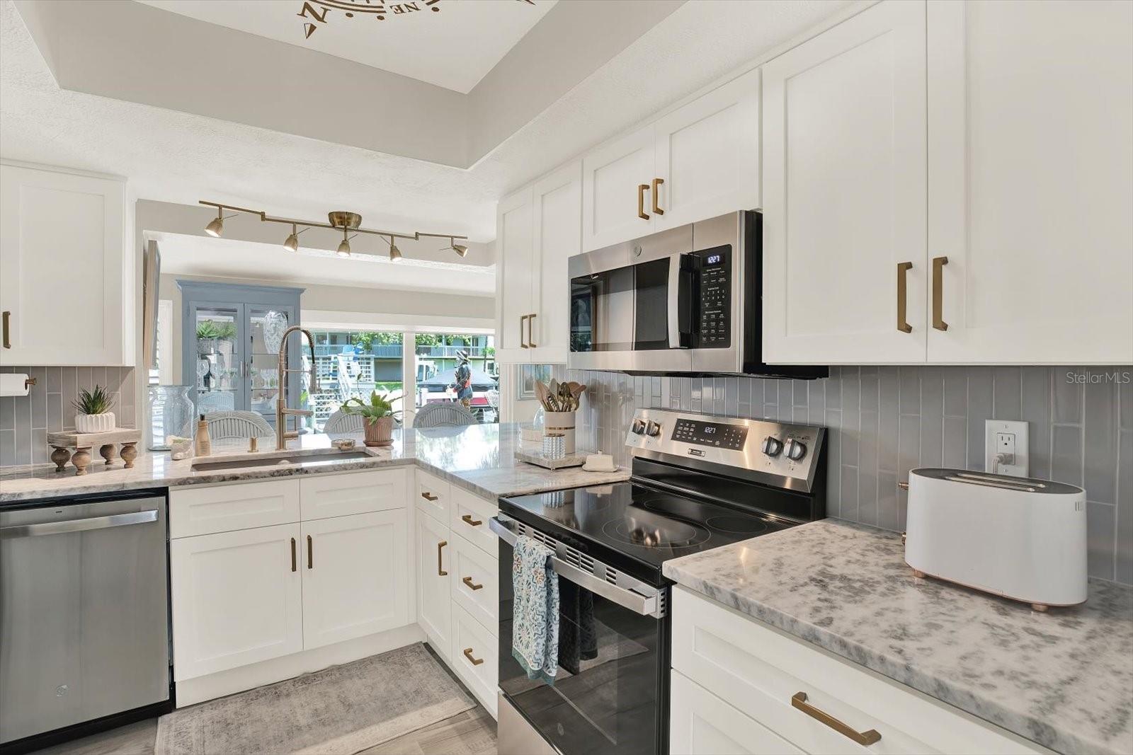 Granite counter tops, brass finishes,  all new GE appliances.  Water view from kitchen.
