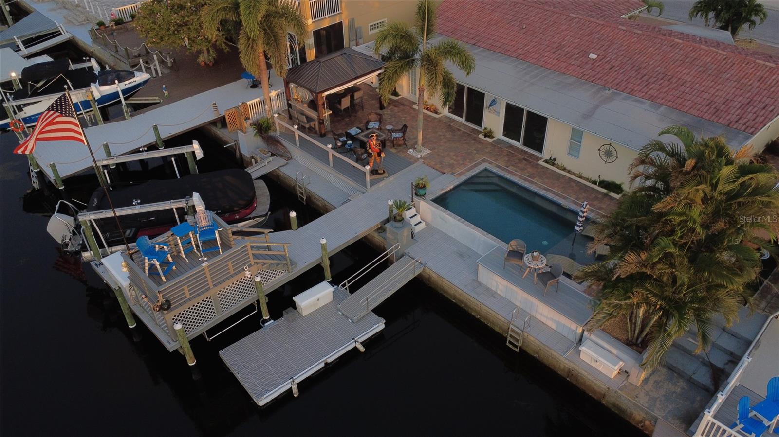 Outdoor kitchen is covered with ample seating. BULL gas grill + fridge.  Fire Pit
