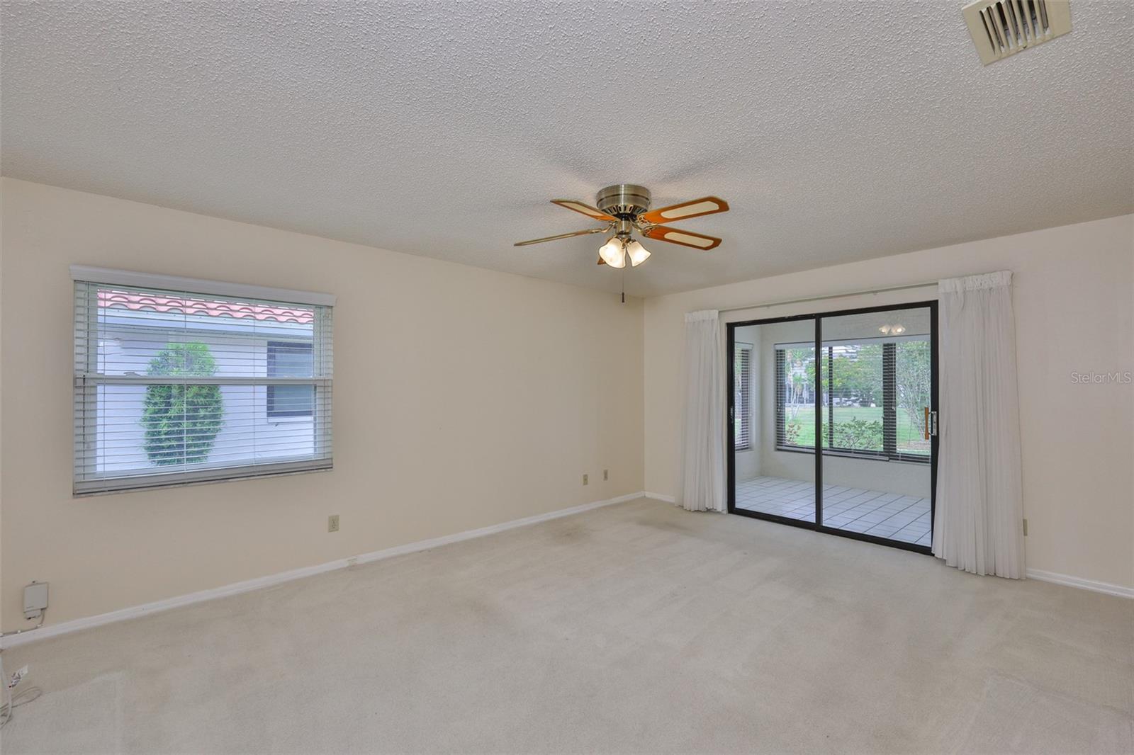 Primary bedroom, (split plan), sliders to Florida Room, garden view.