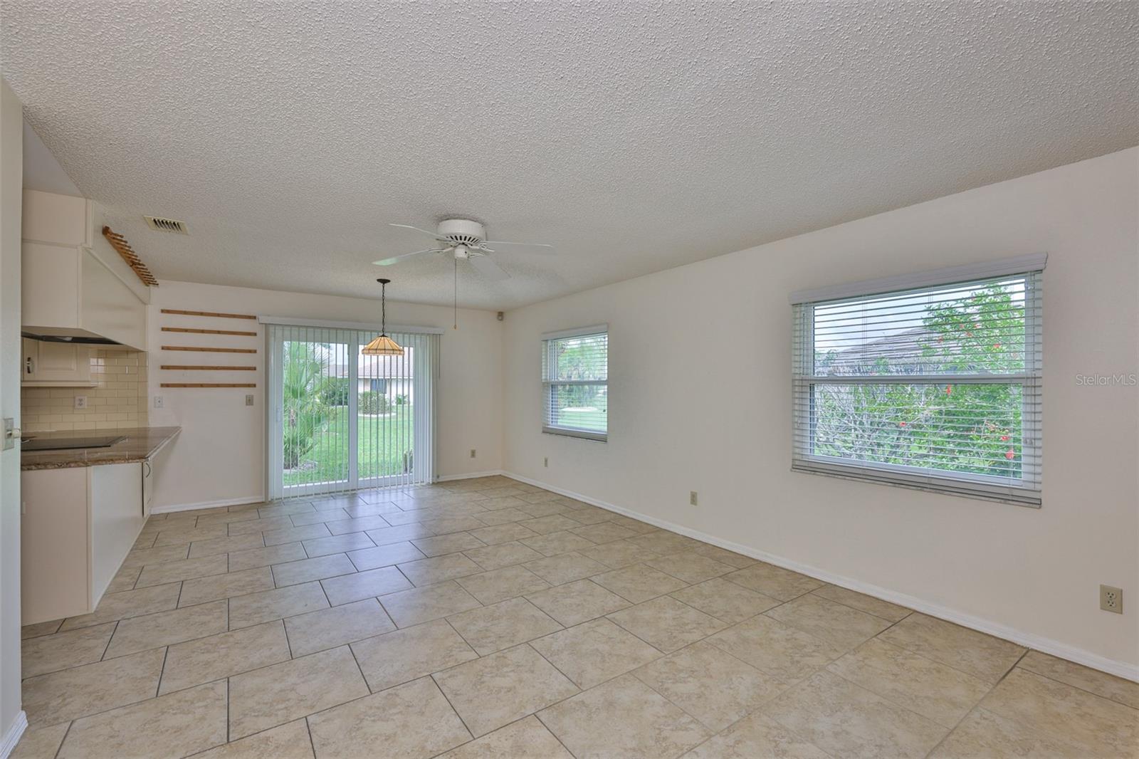 Family Room looking to kitchen breakfast bar and dinette, sliders to patio and garden.