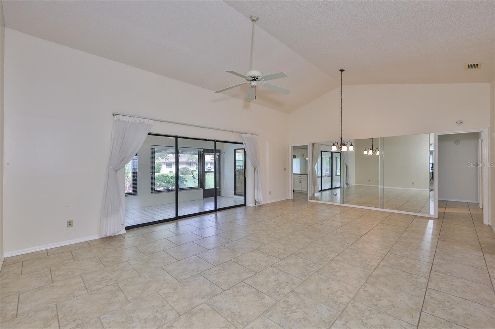 Left - Florida Room with "disappearing wall" sliders, dining room mirrored area, left center to kitchen, right to laundry / golf cart garage / garage, bath 2 and bedroom 2