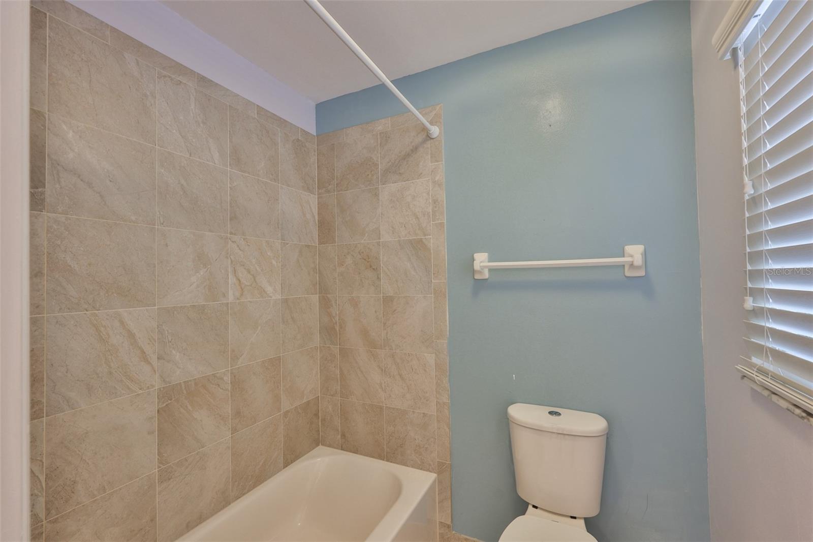 Private water closet with tub and shower combination.