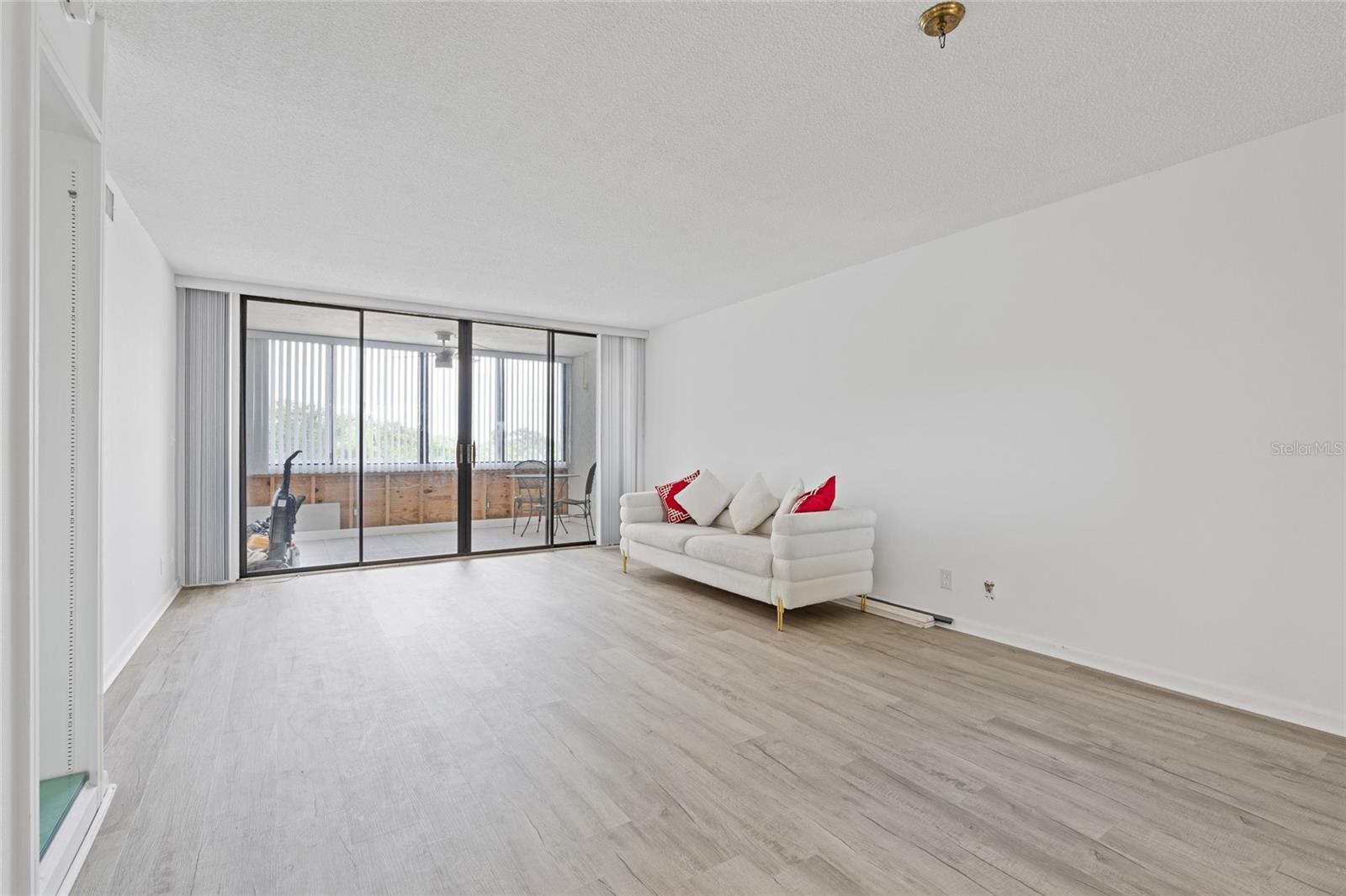 Very spacious living room.  Don't mind the work tools in the balcony; you will have a brand new wall to enjoy when done.