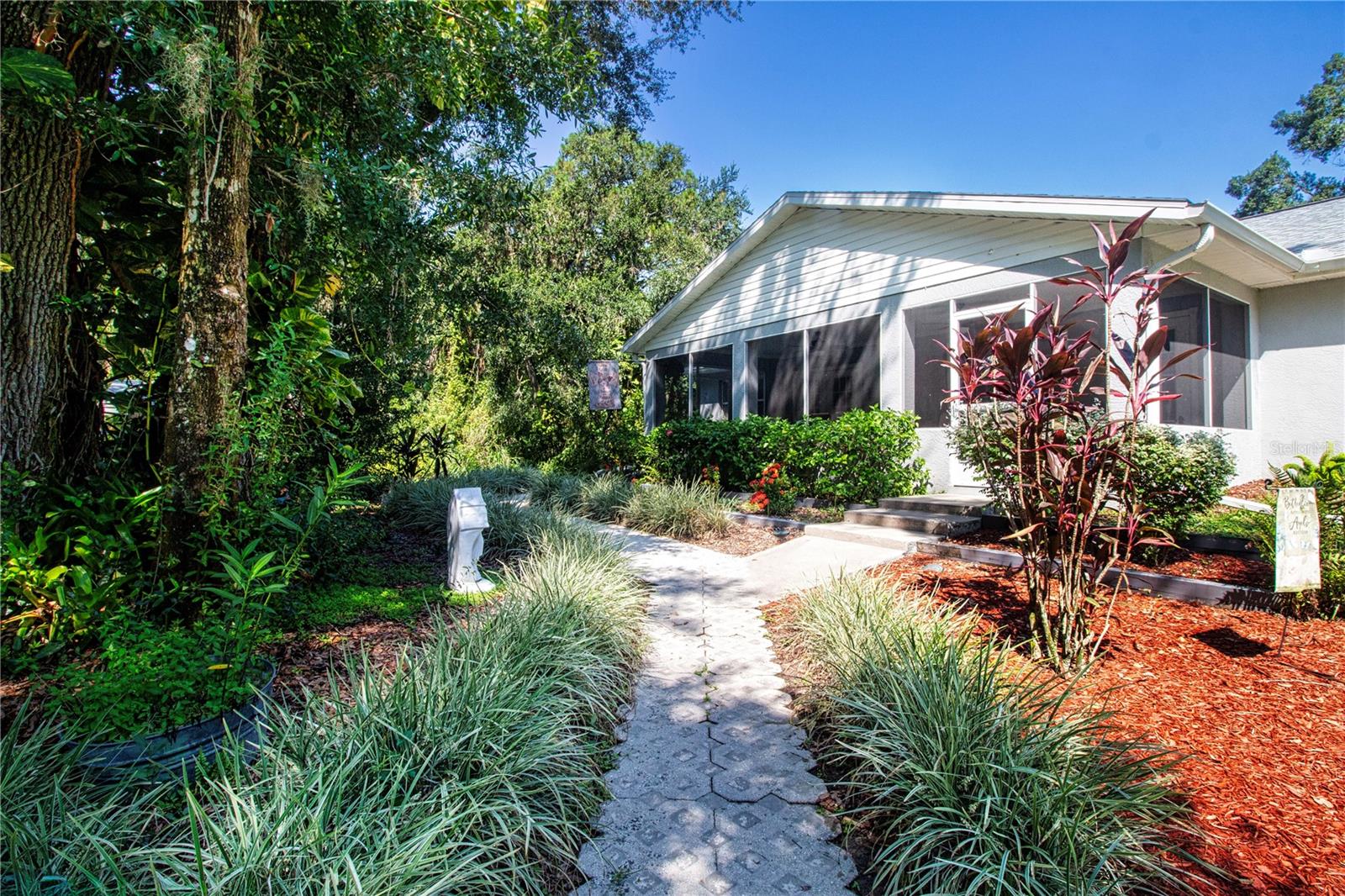 Paver Path Extends Through A well Landscaped Back Yard.