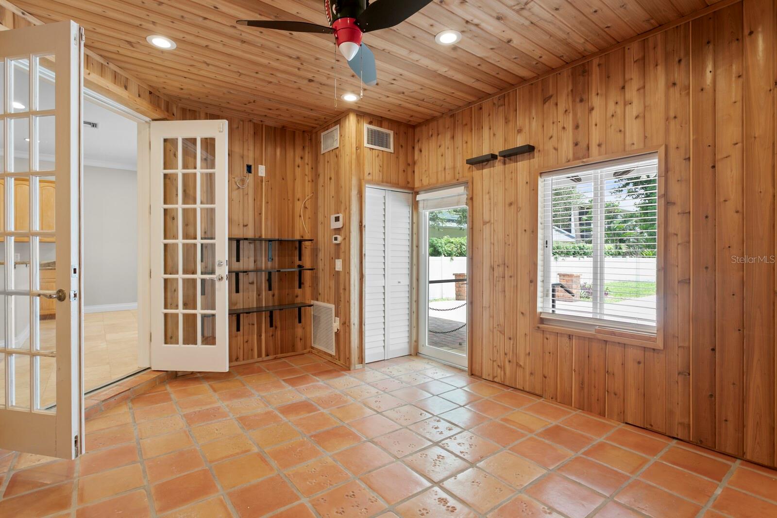French doors and terra cotta tiles accent the den