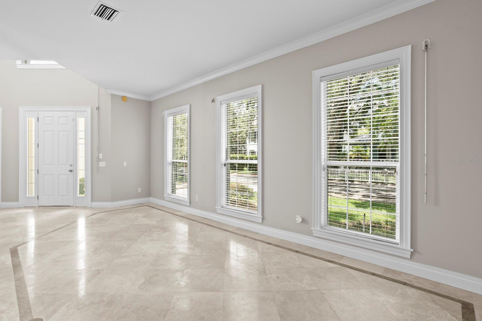 Front entry opens to the formal living room with 3 large windows