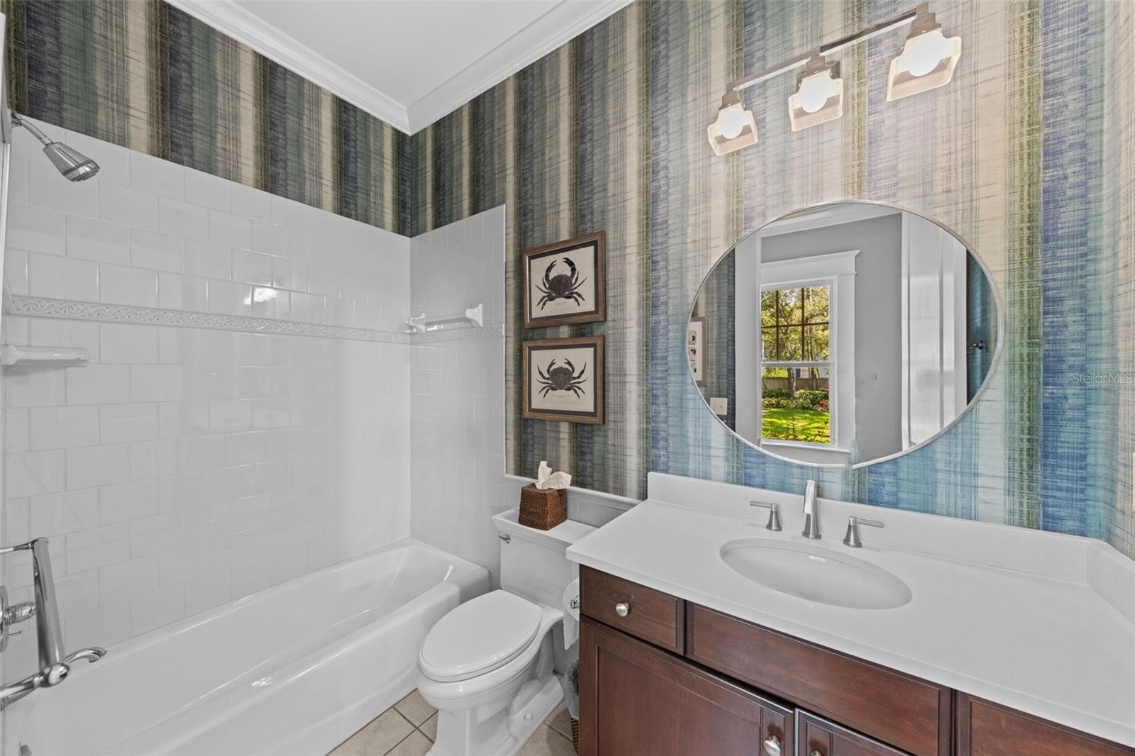 Back downstairs, beyond the kitchen is a full pool bath with side entry from the backyard