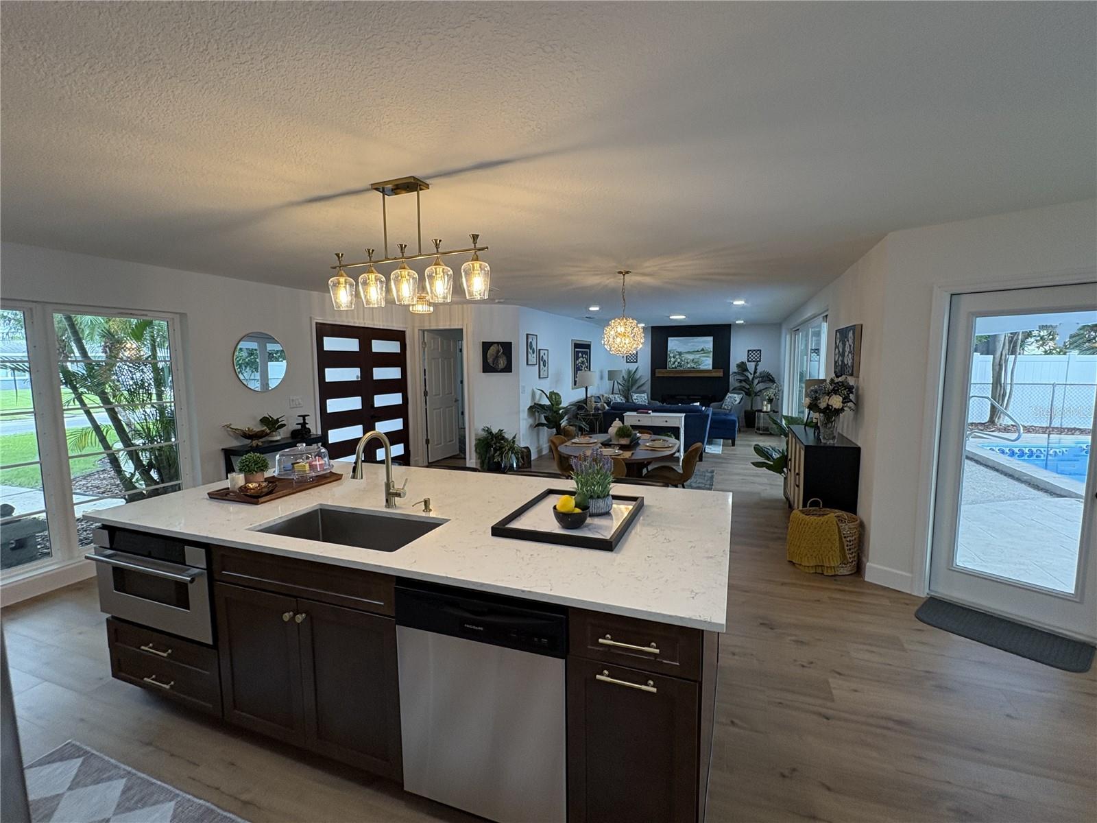 An expansive view that includes front yard, dining, living, dinette and the pool.