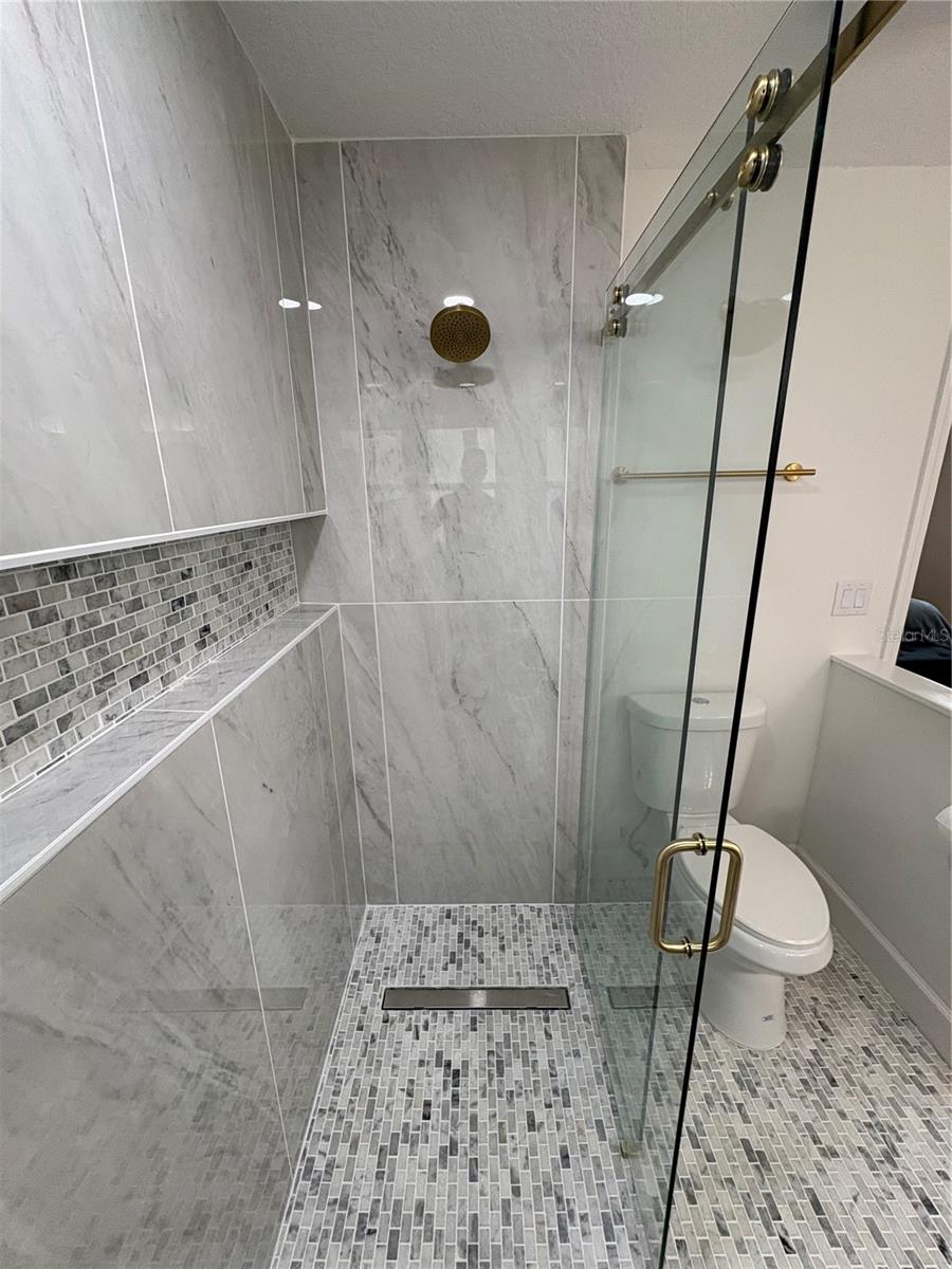 The custom details extend to the full length niche and the shower handle on the back wall.