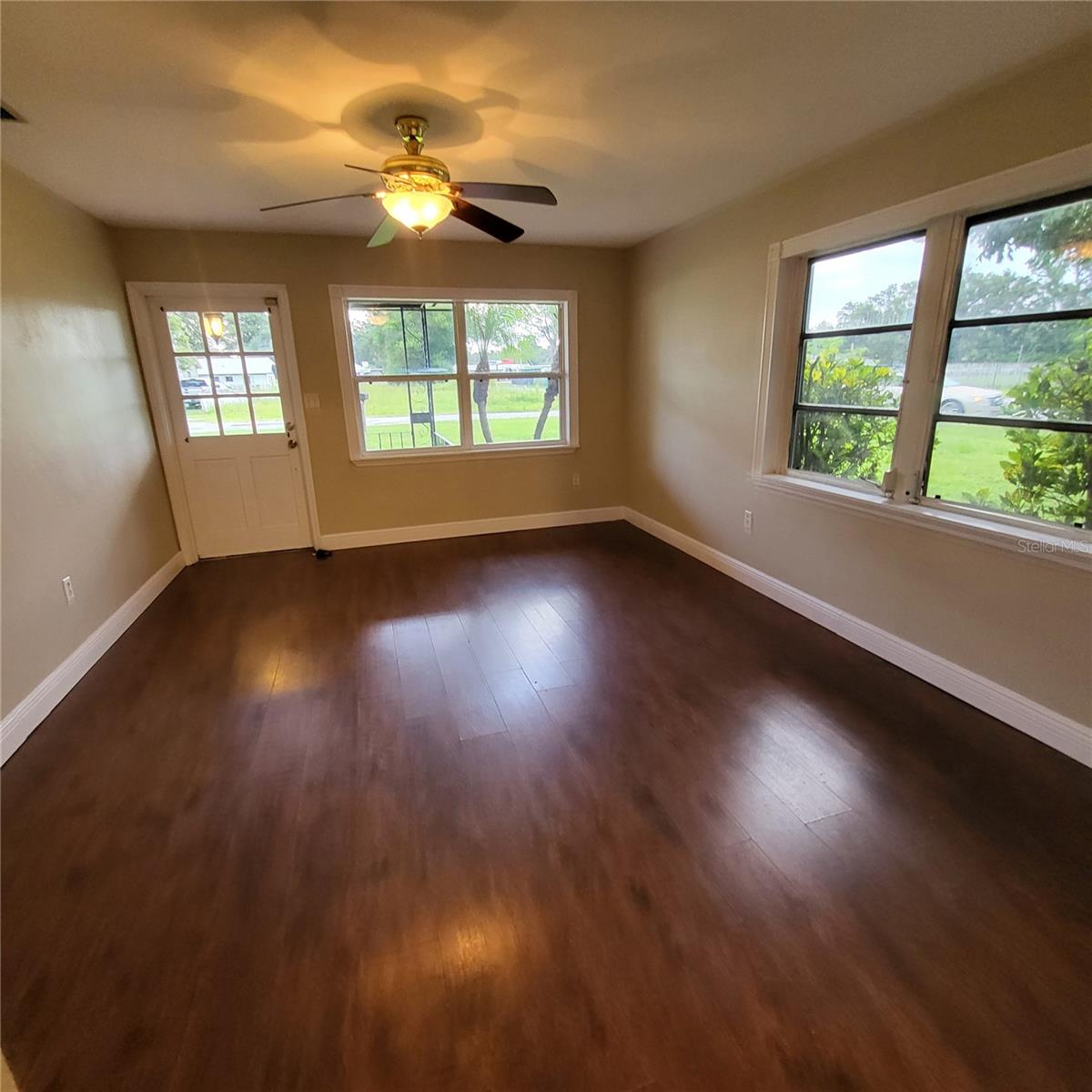 View of living room to front door.   Open & bright!