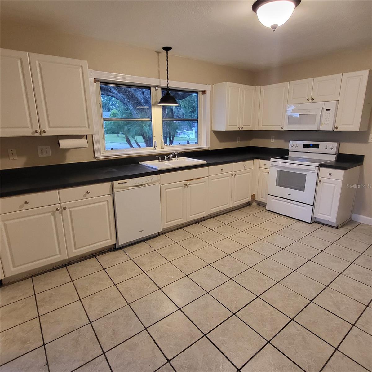 Large picture window above the kitchen sink allows natural light.