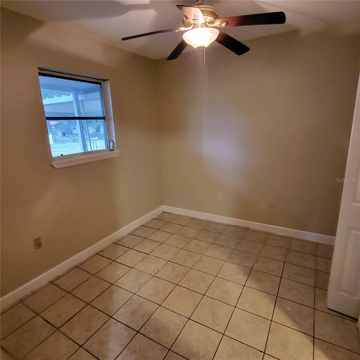 Side bedroom located past kitchen & bonus room has tile flooring, a ceiling fan & has been freshly painted