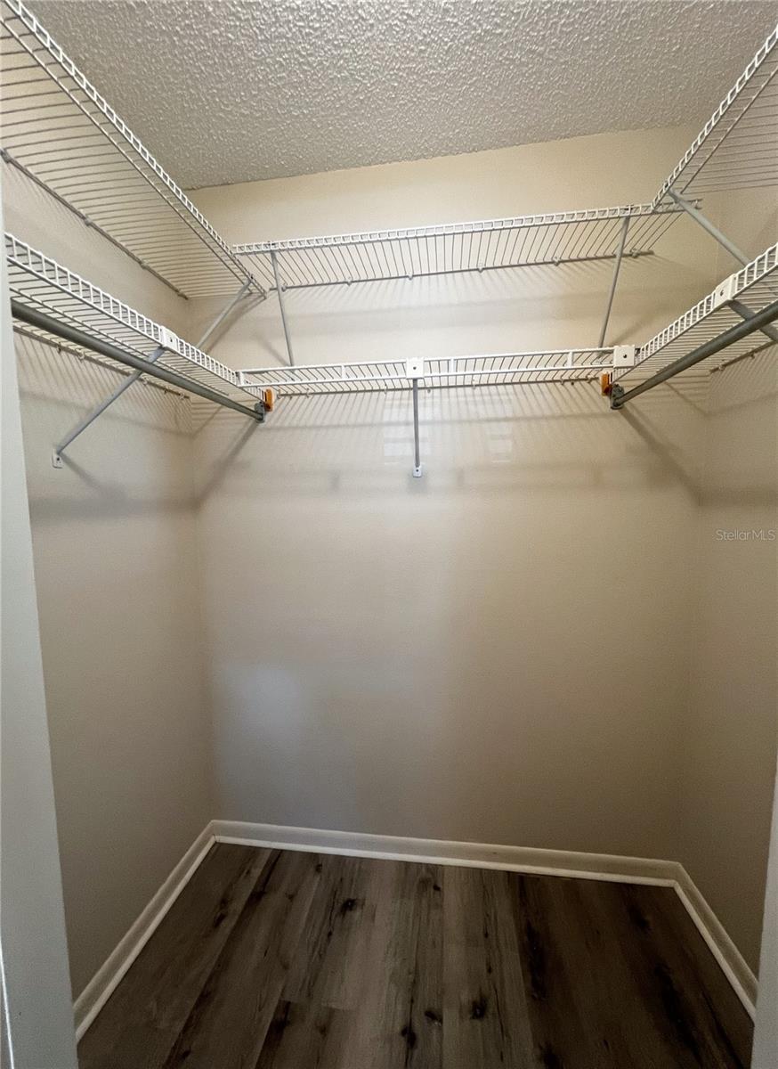 Walk in closet in the second bedroom with shelving.