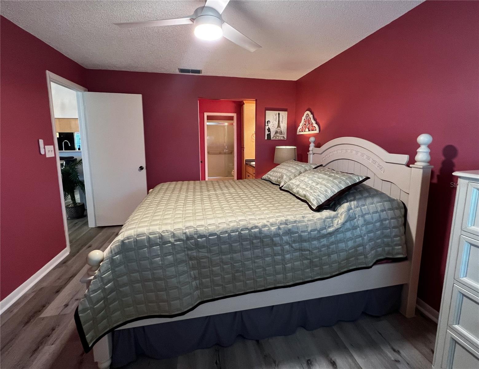 Primary suite with a private attached bathroom and a walk in shower.