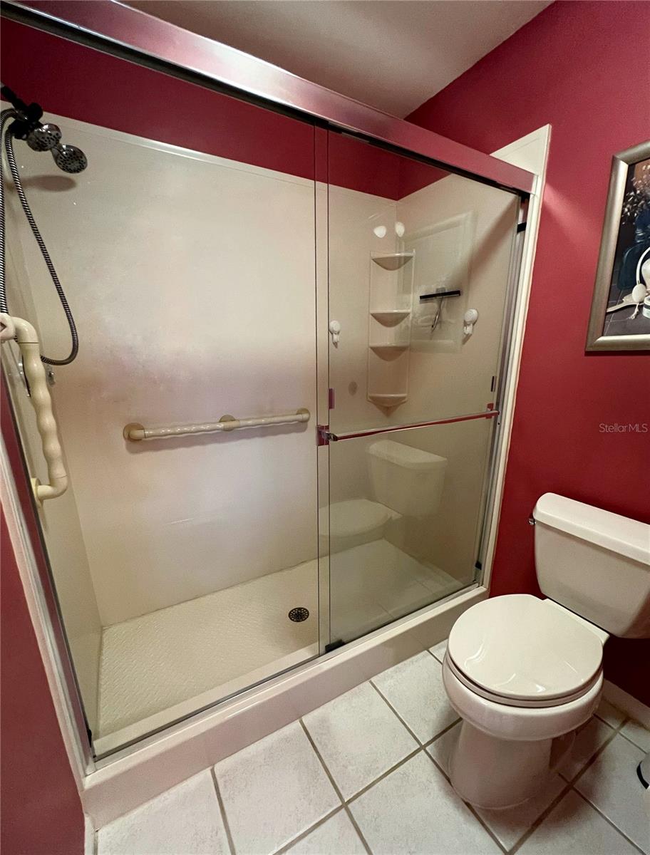 Walk in shower with grab bars in the primary bathroom.