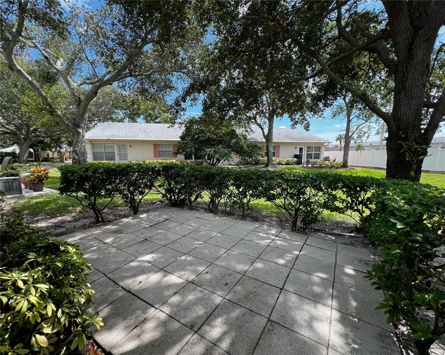 Paver patio with hedges for privacy- perfect for a sitting area, grill space, or plants of your choice!