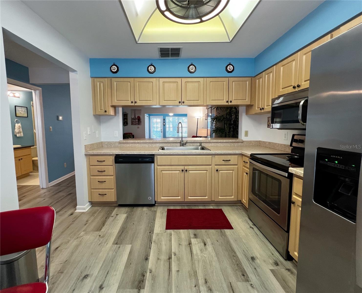 View of the kitchen looking towards the living room, with the guest bedroom and bathroom off to the left.