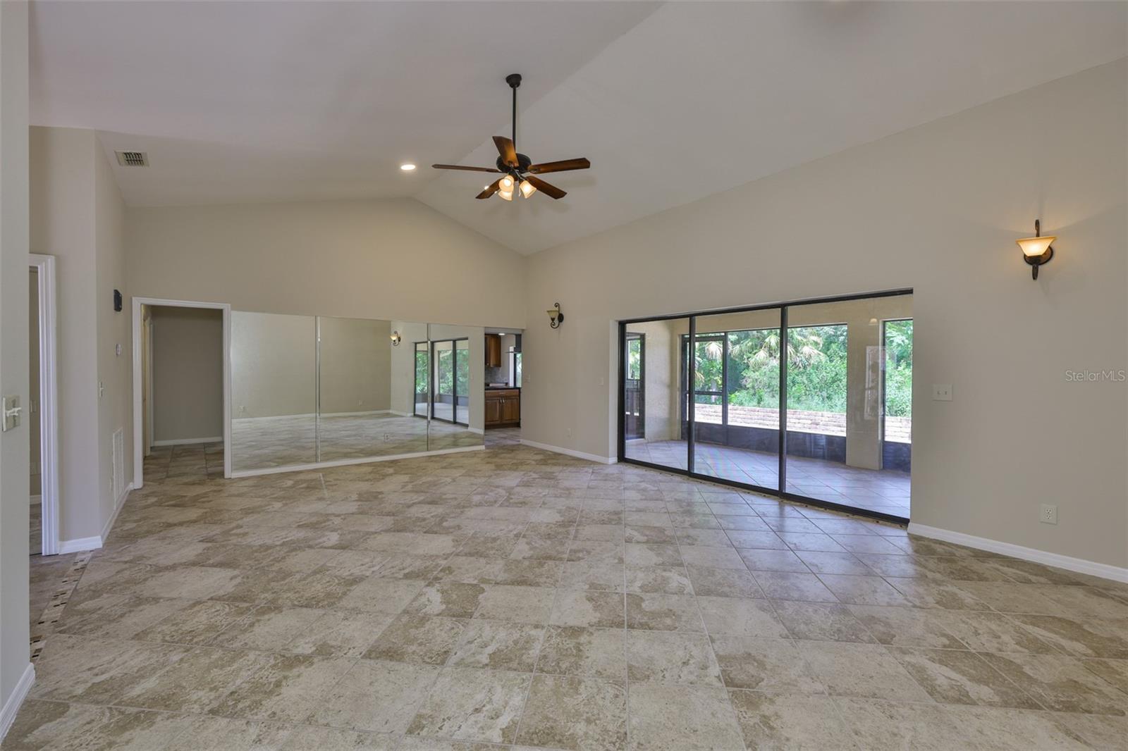 View of the great room leading into the Kitchen and out onto the covered Lanai overlooking the private back yard.