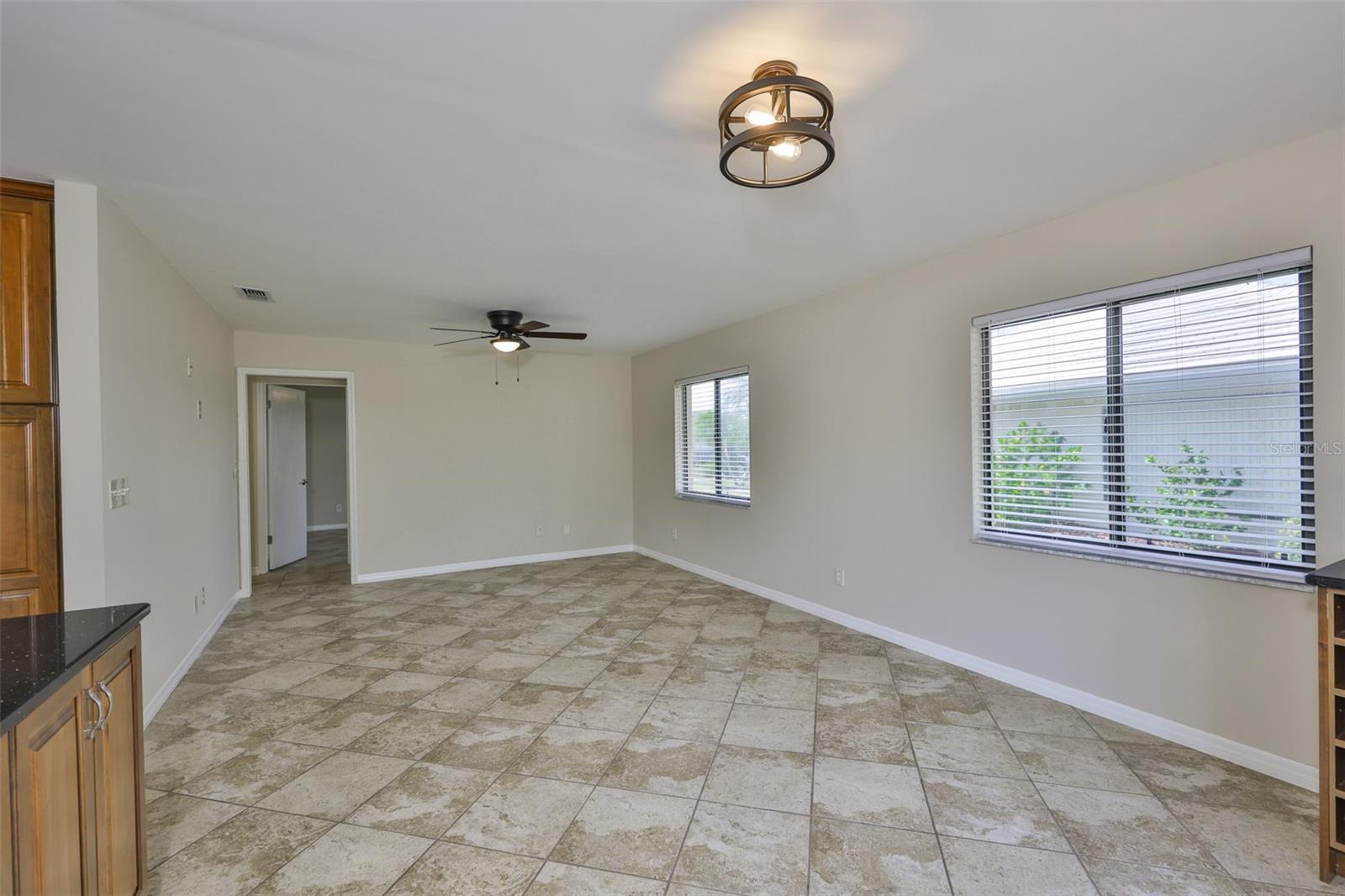 The great room is perfect for creating another space to relax and enjoy company. Notice the modern custom lighting fixtures and ample natural lighting.