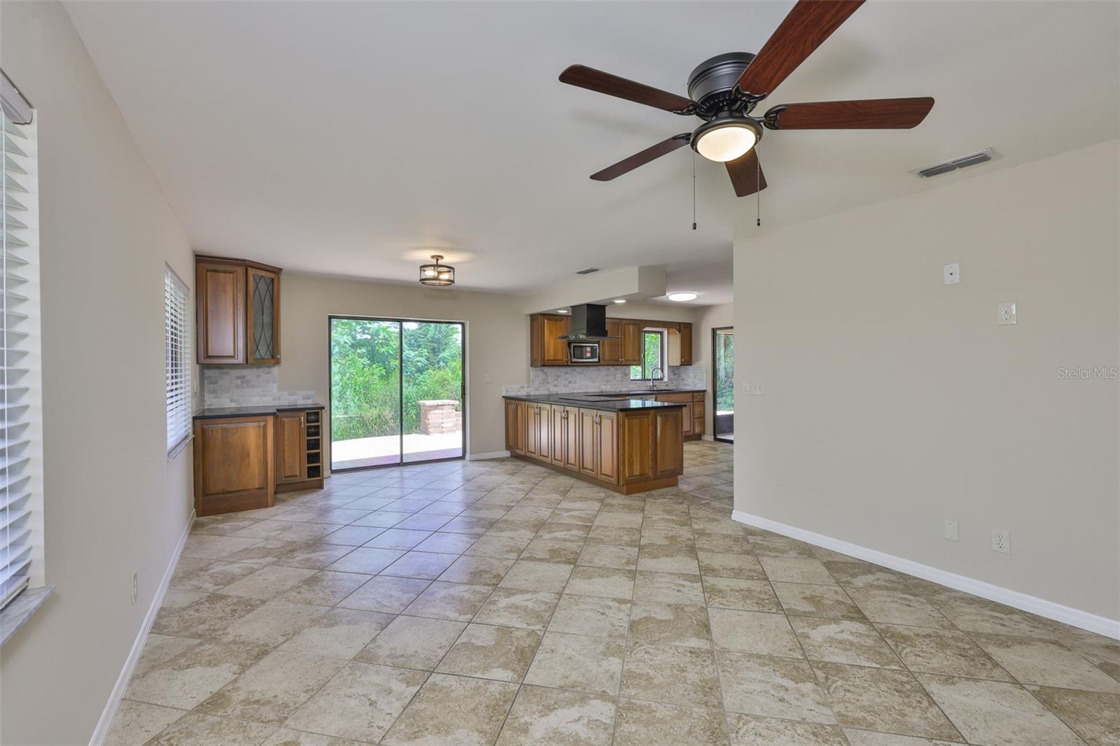 Large open dining/family room combo area leads out onto the back paved patio and encompasses a stunning secluded view.